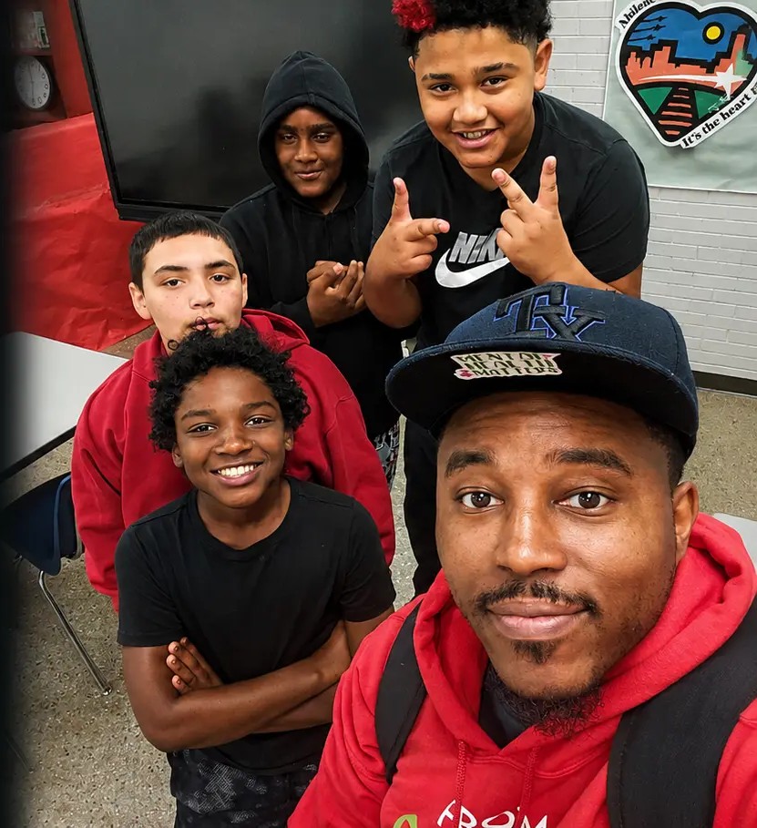 A mentor leading a group of students in a Mann STEAM Academy classroom.